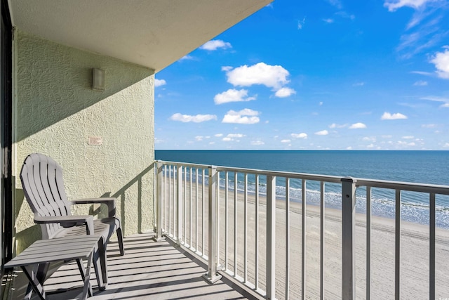 balcony featuring a water view and a view of the beach