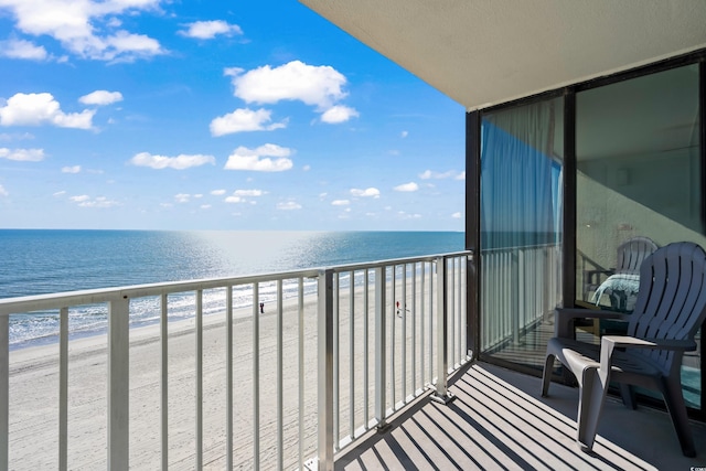 balcony featuring a beach view and a water view