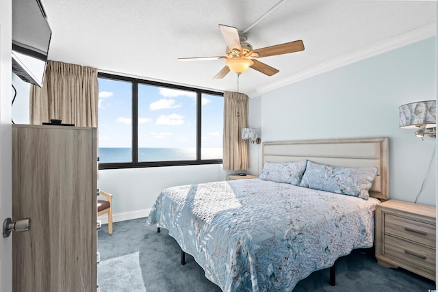 carpeted bedroom with ceiling fan, a water view, ornamental molding, and a textured ceiling