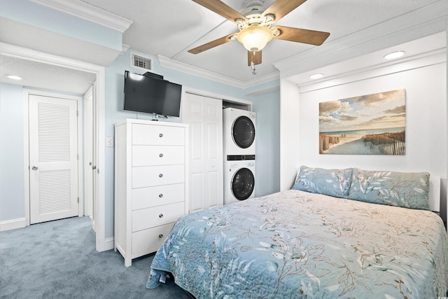 carpeted bedroom with ceiling fan, stacked washer / drying machine, and ornamental molding