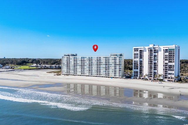 drone / aerial view featuring a water view and a beach view