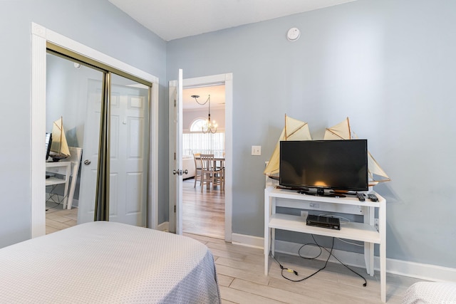 bedroom with a closet, light hardwood / wood-style flooring, and a notable chandelier