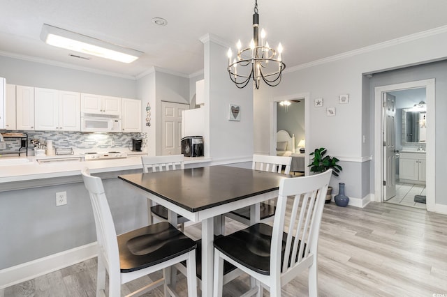 dining room featuring light wood-type flooring, an inviting chandelier, and ornamental molding