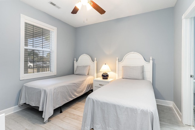 bedroom featuring multiple windows, light hardwood / wood-style flooring, and ceiling fan