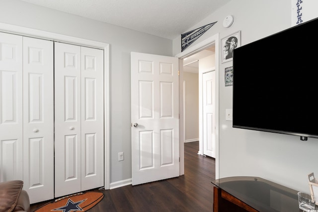 bedroom featuring dark hardwood / wood-style flooring, a closet, and a textured ceiling