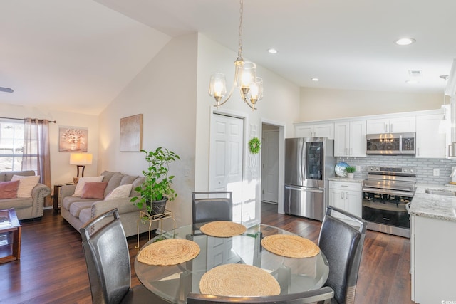 dining space featuring dark hardwood / wood-style flooring, sink, high vaulted ceiling, and a chandelier