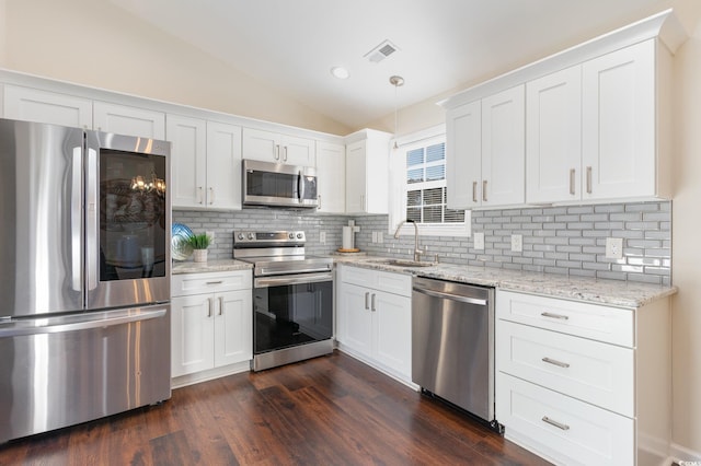 kitchen featuring sink, vaulted ceiling, white cabinets, and appliances with stainless steel finishes