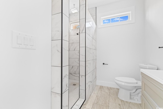 bathroom featuring tiled shower, vanity, and toilet