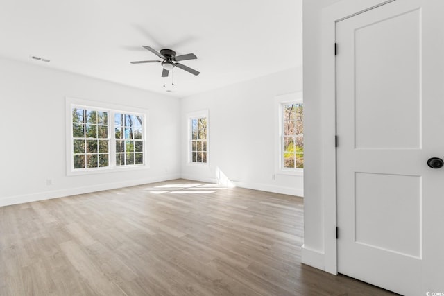 empty room with ceiling fan and light hardwood / wood-style flooring