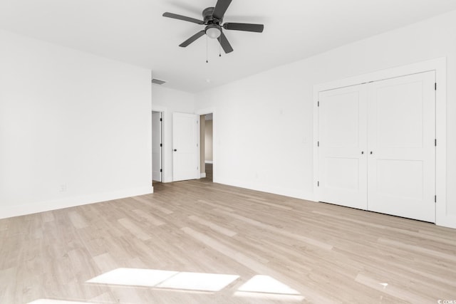 unfurnished bedroom featuring ceiling fan, light hardwood / wood-style flooring, and a closet