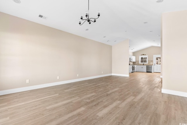 unfurnished living room featuring light hardwood / wood-style floors, lofted ceiling, and an inviting chandelier