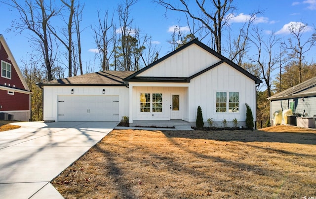 view of front of property with a front yard, a garage, and central AC unit