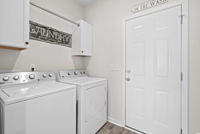 laundry area with cabinets, hardwood / wood-style floors, and washer and dryer