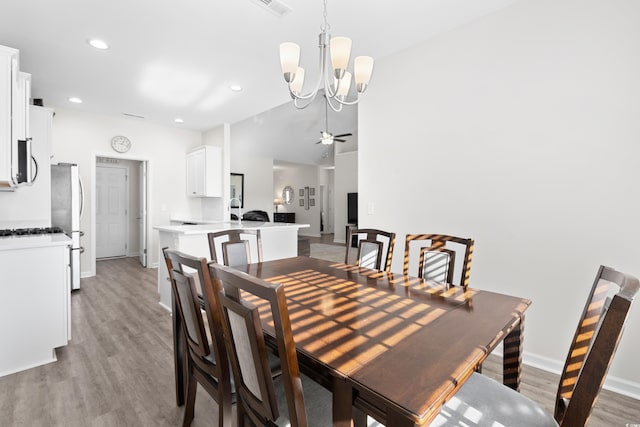 dining space with light hardwood / wood-style floors and ceiling fan with notable chandelier