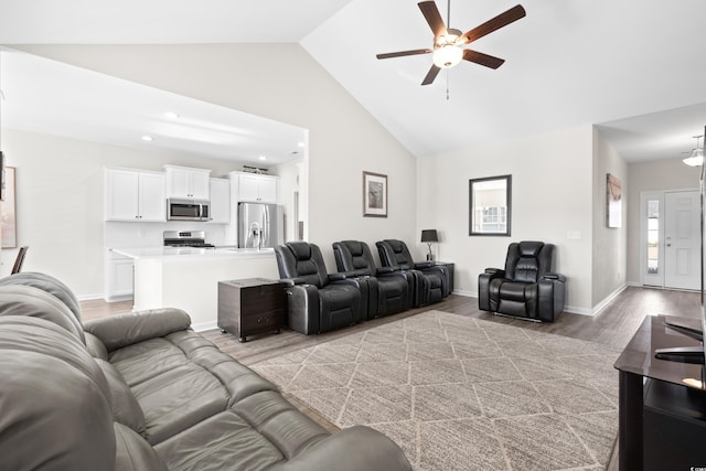 living room featuring ceiling fan, high vaulted ceiling, and light hardwood / wood-style flooring