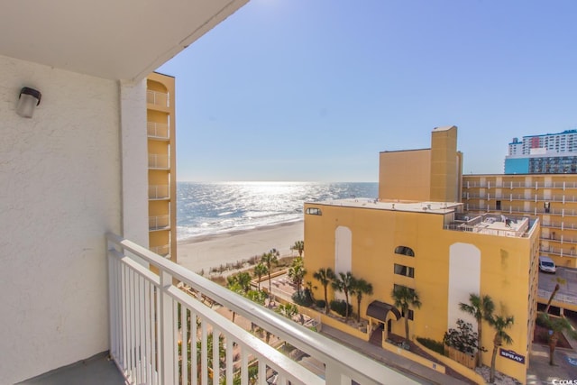 balcony with a water view and a view of the beach