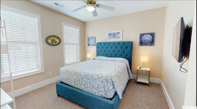 carpeted bedroom with baseboards, visible vents, and a ceiling fan