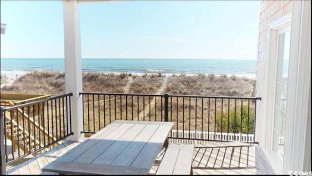 balcony featuring a water view and a beach view