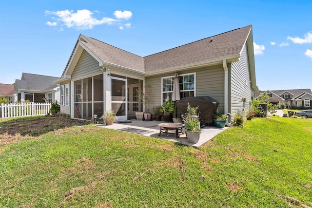 back of house with a fire pit, a sunroom, a yard, and a patio area