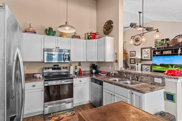 kitchen with hanging light fixtures, stainless steel appliances, kitchen peninsula, and white cabinets