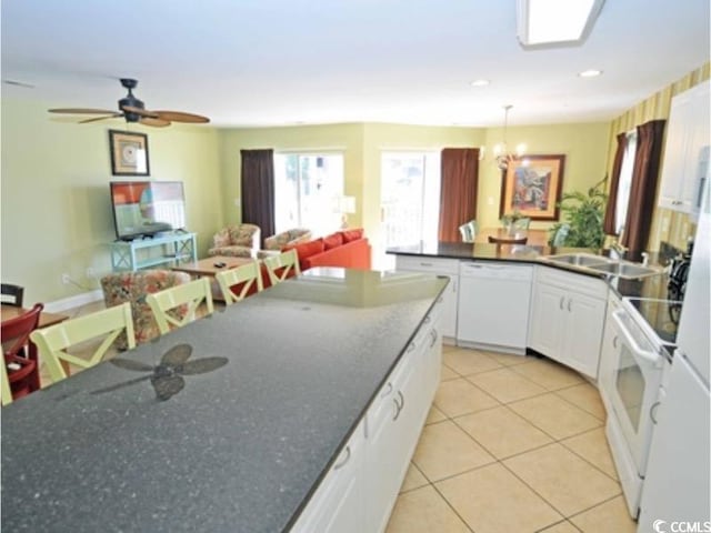 kitchen with open floor plan, white cabinets, light tile patterned flooring, white appliances, and a peninsula