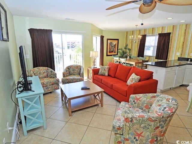 living room with ceiling fan with notable chandelier and light tile patterned floors