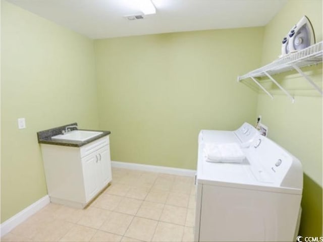 laundry area featuring washing machine and dryer, a sink, visible vents, baseboards, and cabinet space