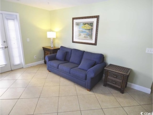 living area with baseboards and light tile patterned floors