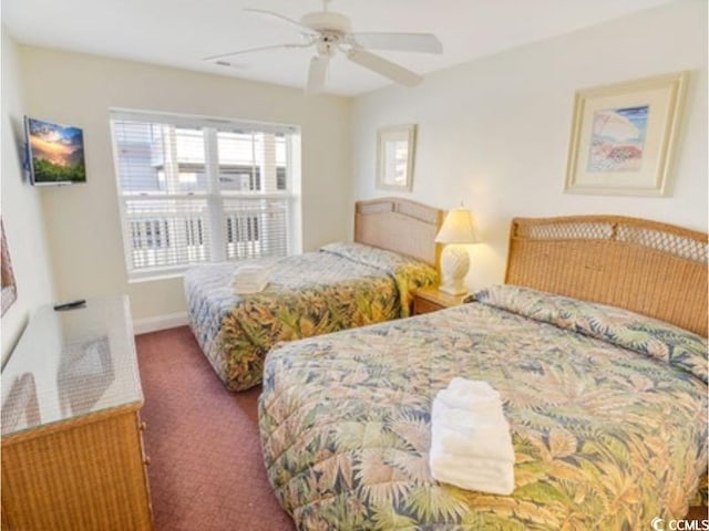 carpeted bedroom featuring baseboards and a ceiling fan