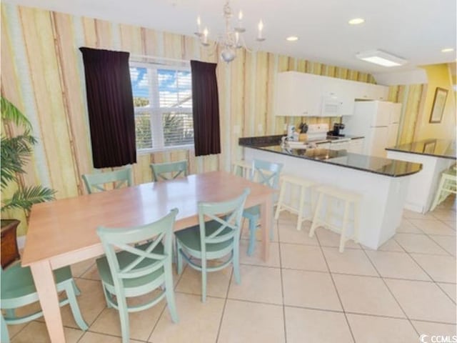 dining area with light tile patterned floors, recessed lighting, an inviting chandelier, and wallpapered walls