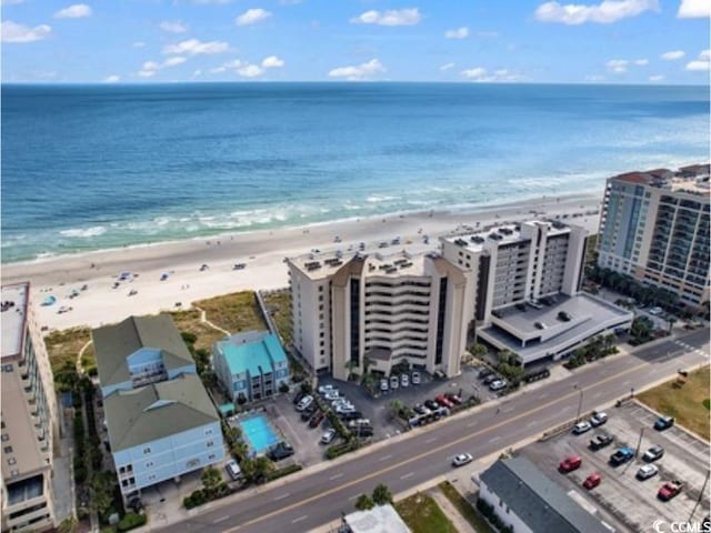 bird's eye view featuring a water view and a beach view