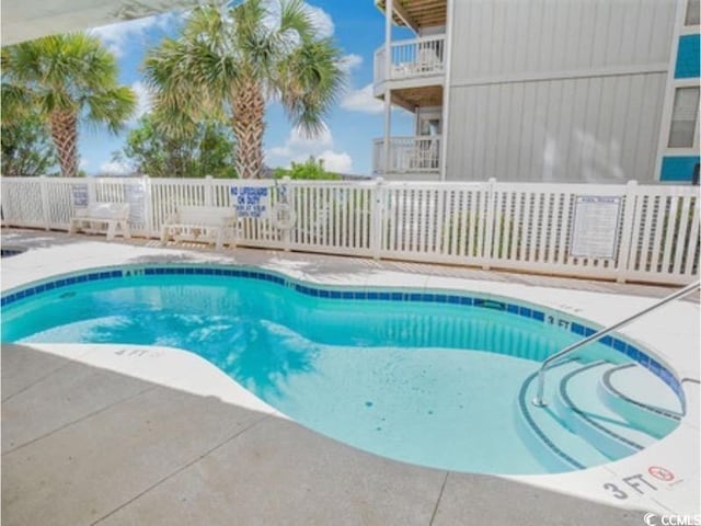 view of swimming pool with a patio area, fence, and a pool