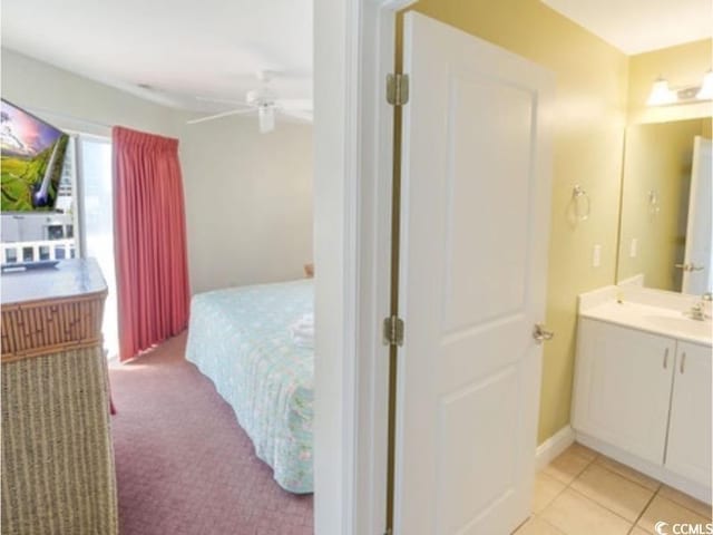 bedroom featuring light tile patterned floors, a ceiling fan, and a sink