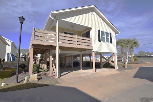 view of front of home with a deck, a carport, and ceiling fan