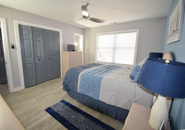 bedroom featuring ceiling fan, a closet, and light wood-type flooring