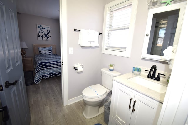 bathroom with toilet, vanity, and hardwood / wood-style flooring