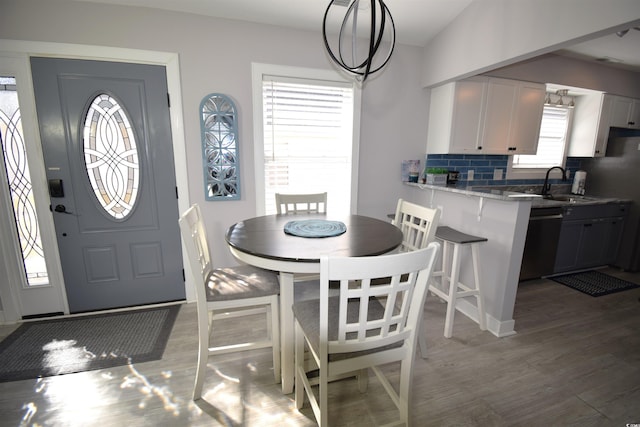 dining area featuring sink, hardwood / wood-style floors, plenty of natural light, and an inviting chandelier