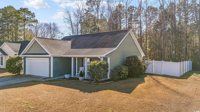 view of front of home with covered porch, a front yard, and a garage