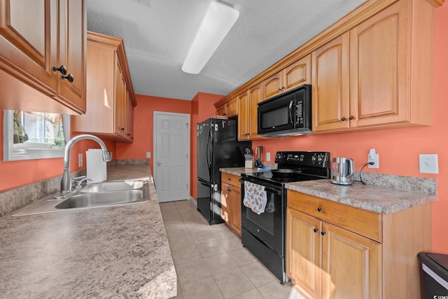 kitchen featuring sink, light tile patterned floors, and black appliances