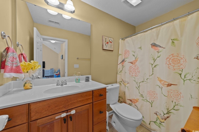 bathroom with vanity, tile patterned floors, a textured ceiling, and toilet