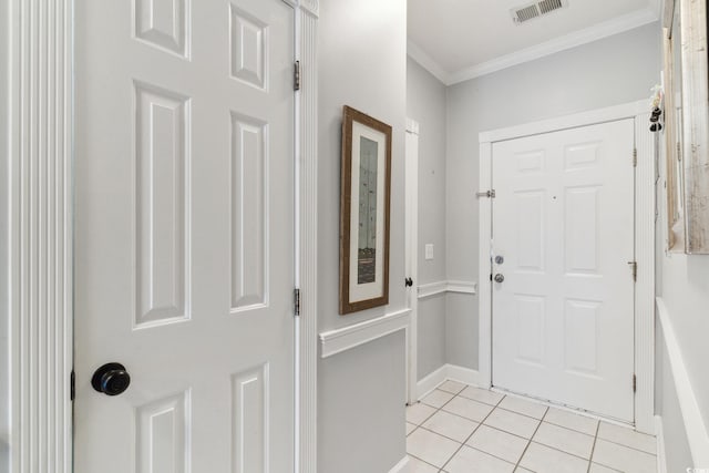 entryway with light tile patterned floors and ornamental molding