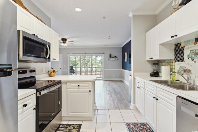 kitchen with white cabinetry, kitchen peninsula, sink, and appliances with stainless steel finishes