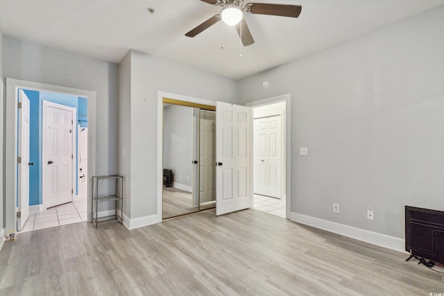 unfurnished bedroom featuring ceiling fan, a closet, and light hardwood / wood-style floors