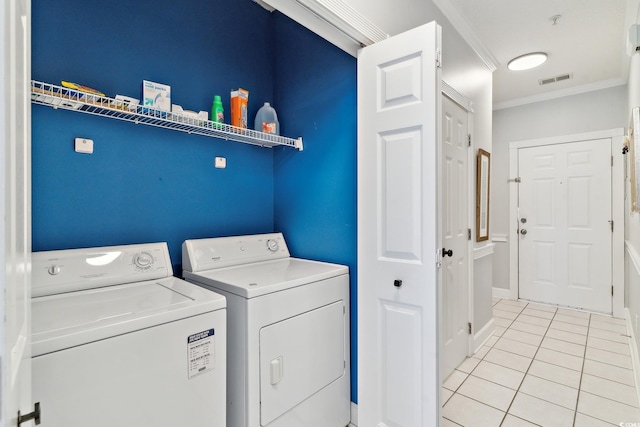 washroom featuring independent washer and dryer, crown molding, and light tile patterned floors