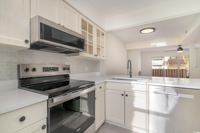 kitchen with decorative backsplash, white cabinetry, sink, and appliances with stainless steel finishes