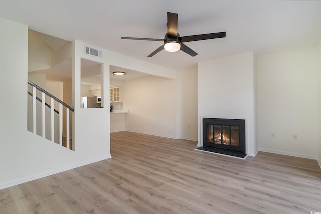 unfurnished living room with ceiling fan and light hardwood / wood-style flooring