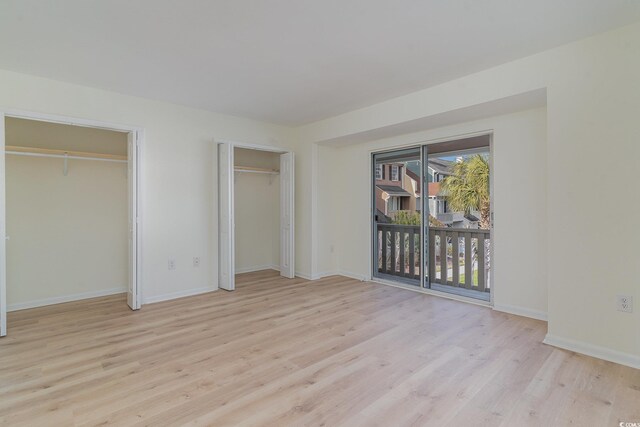 unfurnished bedroom featuring access to exterior and light hardwood / wood-style floors