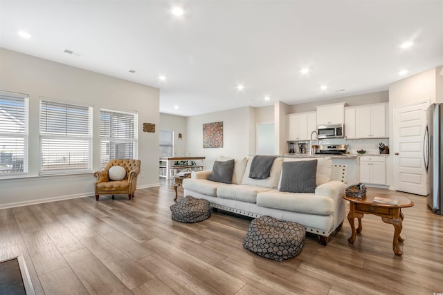 living room with visible vents, recessed lighting, baseboards, and light wood-style floors