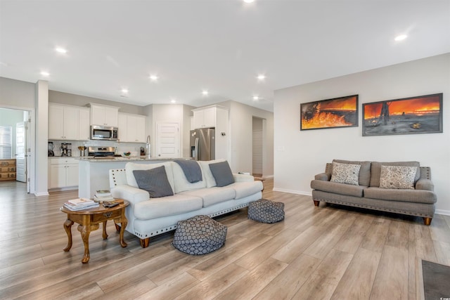 living area featuring light wood finished floors, recessed lighting, and baseboards