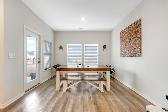 dining room featuring visible vents, baseboards, and light wood finished floors